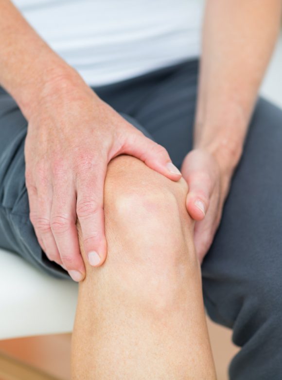 Woman having knee pain in medical office